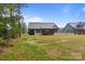 View of the rear of the house and backyard featuring a well-maintained lawn at 153 Mills Garden Rd, Statesville, NC 28625