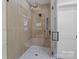 Luxurious walk-in shower featuring unique tiling, a rainfall showerhead and seamless glass doors at 153 Mills Garden Rd, Statesville, NC 28625