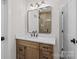 Modern bathroom featuring a wooden vanity with white countertop and a large, framed mirror at 153 Mills Garden Rd, Statesville, NC 28625