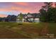 Picturesque home at dusk with manicured lawn, highlighting its inviting facade and neighborhood charm at 153 Mills Garden Rd, Statesville, NC 28625