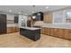 Modern kitchen with center island, sleek black appliances, light wood cabinets, and stylish pendant lighting at 153 Mills Garden Rd, Statesville, NC 28625