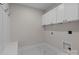 Well-organized laundry room with upper cabinets and ample space for appliances and storage at 153 Mills Garden Rd, Statesville, NC 28625