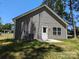 Backyard featuring a well-maintained yard, AC unit, and back door leading to a concrete patio at 1604 N Main St, Mount Holly, NC 28120