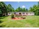 Open backyard with an inviting wooden deck, landscaping, and surrounded by trees at 161 Crystal Bay Dr, Mooresville, NC 28115