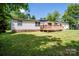 Lovely backyard featuring a wooden deck with an umbrella and mature trees at 161 Crystal Bay Dr, Mooresville, NC 28115