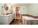 Bright bathroom featuring a double vanity, soaking tub, and wood-look flooring at 161 Crystal Bay Dr, Mooresville, NC 28115