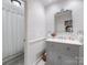 Half bath with framed mirror, updated vanity, and patterned wallpaper at 161 Perrin Pl, Charlotte, NC 28207