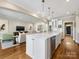 Open kitchen with island seating, stainless steel appliances, and access to living room at 161 Perrin Pl, Charlotte, NC 28207
