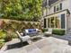 Beautiful stone patio with outdoor seating area, privacy wall, and manicured landscaping at 161 Perrin Pl, Charlotte, NC 28207