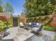 Outdoor stone patio with seating, brick privacy wall, landscaping and black wood gate at 161 Perrin Pl, Charlotte, NC 28207