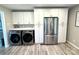 Bright kitchen featuring stainless steel refrigerator, white cabinetry, and modern laundry appliances at 1928 Londonberry Dr, Rock Hill, SC 29730