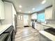 Bright kitchen featuring stainless steel appliances, white cabinetry, and stylish light grey wood flooring at 1928 Londonberry Dr, Rock Hill, SC 29730