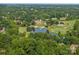 Picturesque aerial view showcasing the golf course and scenic pond within a lush, green community at 19679 Wooden Tee Dr, Davidson, NC 28036