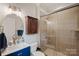 Stylish bathroom featuring a modern vanity, wall cabinet, and glass-enclosed tiled shower at 19679 Wooden Tee Dr, Davidson, NC 28036