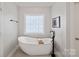 Soaking tub with a view of the decorative window at 19679 Wooden Tee Dr, Davidson, NC 28036