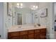 Well-lit bathroom highlighting a double sink vanity with framed mirrors and neutral paint at 19679 Wooden Tee Dr, Davidson, NC 28036