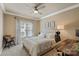 Cozy bedroom showcasing neutral walls, white bedding, a ceiling fan, and a wooden desk with an office chair at 19679 Wooden Tee Dr, Davidson, NC 28036