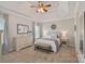 Inviting bedroom showcases a trey ceiling, neutral walls, soft carpet, and dresser with mirror and bench at 19679 Wooden Tee Dr, Davidson, NC 28036