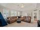 Inviting bonus room showcasing a plush brown sectional sofa, ottoman, and bright natural light at 19679 Wooden Tee Dr, Davidson, NC 28036