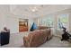 Spacious bonus room featuring a comfortable brown sofa, ample natural light, and neutral decor at 19679 Wooden Tee Dr, Davidson, NC 28036