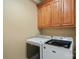 Functional laundry area with front-load washer and dryer under wood cabinets at 19679 Wooden Tee Dr, Davidson, NC 28036