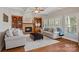 Comfortable living room with coffered ceilings, a fireplace, built-in bookshelves, and bright natural light at 19679 Wooden Tee Dr, Davidson, NC 28036