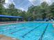 Community lap pool with blue awning, surrounded by lounge chairs, ready for a swim at 19679 Wooden Tee Dr, Davidson, NC 28036