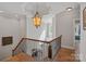 Stairway with chandelier shows the front door and living room below at 19679 Wooden Tee Dr, Davidson, NC 28036
