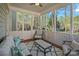 Bright sunroom with comfortable seating, screened windows, and tranquil outdoor views at 19679 Wooden Tee Dr, Davidson, NC 28036
