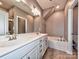 Elegant bathroom featuring double sinks, a soaking tub, and a separate shower at 2001 Laurel Village Cir, Belmont, NC 28012