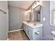 Modern bathroom with dual sinks, gray cabinets, and tile flooring at 2001 Laurel Village Cir, Belmont, NC 28012