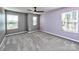 Bright bedroom featuring neutral gray walls, plush carpeting, and natural light from three windows at 2001 Laurel Village Cir, Belmont, NC 28012