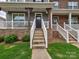 Close-up of a townhouse entrance with stone veneer, leading up to a black front door and porch at 2001 Laurel Village Cir, Belmont, NC 28012