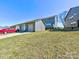 View of the back and garage doors on a sunny day with green grass and gray siding at 2001 Laurel Village Cir, Belmont, NC 28012