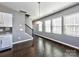 Open-concept living area with hardwood floors, staircase, and bright windows connecting the living and kitchen spaces at 2001 Laurel Village Cir, Belmont, NC 28012