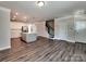 Open layout shows kitchen island, modern appliances, wood floors, and staircase to the upper level at 2001 Laurel Village Cir, Belmont, NC 28012