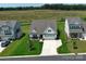 Aerial view of a well-maintained home with a lush green lawn, a two-car garage, and a neighboring field at 2048 Turnsberry Dr, Monroe, NC 28112