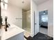 Stylish bathroom with a glass shower, double vanity, and black hexagon tiles leading to the bedroom at 2048 Turnsberry Dr, Monroe, NC 28112