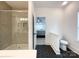 Bright bathroom featuring a glass-enclosed shower, black hexagon tile, and an open doorway to a bedroom at 2048 Turnsberry Dr, Monroe, NC 28112