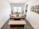 Elegant dining room featuring a wood table, upholstered chairs and bench, and stylish chandelier at 2048 Turnsberry Dr, Monroe, NC 28112
