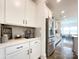 Well-lit kitchen featuring white cabinetry, stainless steel refrigerator, and coffee station on countertop at 2048 Turnsberry Dr, Monroe, NC 28112