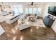 Open living room with hardwood floors, large sectional sofa, and view into the kitchen and breakfast nook at 2048 Turnsberry Dr, Monroe, NC 28112