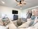 Cozy living room features a ceiling fan, wall-mounted TV, and staircase access to the next level at 2048 Turnsberry Dr, Monroe, NC 28112