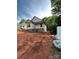 New home construction exhibits framework, brick base, and window installations amidst a spacious, ungraded lot at 208 Malvern Sw Dr, Concord, NC 28025