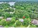Aerial view of a home surrounded by mature trees and lush greenery, near a serene lake at 20812 Decora Dr, Cornelius, NC 28031