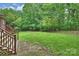 A serene backyard featuring a lush green lawn and stairs leading up from the wooden deck at 20812 Decora Dr, Cornelius, NC 28031