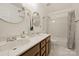 Bathroom with marble countertop, double sinks, mirrors, and shower with tub combination at 20812 Decora Dr, Cornelius, NC 28031