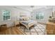 A serene bedroom filled with natural light, wood floors, a cozy rug, and a ceiling fan at 20812 Decora Dr, Cornelius, NC 28031