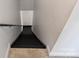 A well-lit staircase with black steps and white walls leads to the lower level at 20812 Decora Dr, Cornelius, NC 28031
