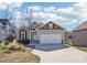 Charming home featuring a two-car garage, stone accents, beautiful landscaping, and a welcoming entrance at 21610 Rio Oro Dr, Cornelius, NC 28031